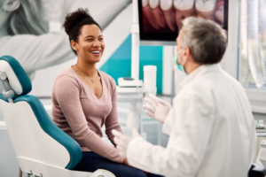 Woman smiling as she talks with her dentist