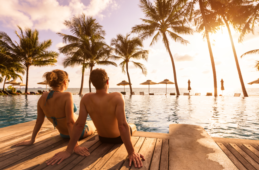 Couple on vacation sitting by beachy pool